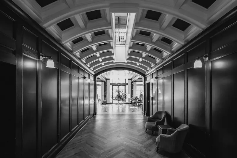 A long arched hallway with wood-panelled walls. Photo by Jordan Ryskamp.